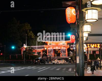 KYOTO, JAPAN - 06. NOVEMBER 2019: Menschen, die nachts auf der Straße vor dem Haupttor des Yasaka Shrine oder Gion Shrine in Kyoto spazieren Stockfoto