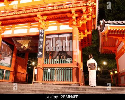 KYOTO, JAPAN - 06. NOVEMBER 2019: Eine junge Besucherin im Kimono am Tor des Yasaka Shrine oder Gion Shrine in Kyoto bei Nacht Stockfoto