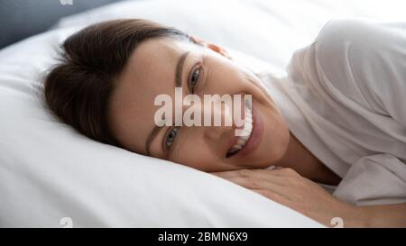 Frau lächelnd erwacht im Bett liegend fühlt sich ausgeruht Nahaufnahme Gesicht Stockfoto