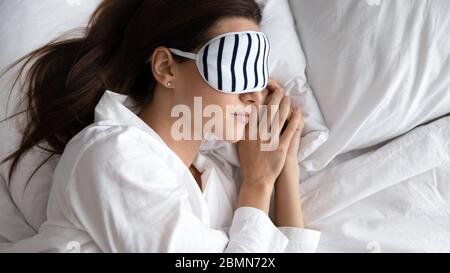 Junge Frau mit Augenmaske genießen süße Träume bequem schlafen Stockfoto