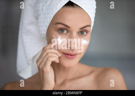 Closeup Porträt Frau Anwendung Nacht oder Tag Gesichtscreme Stockfoto