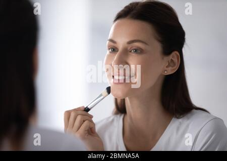 Schöne Frau mit Make-up Pinsel Anwendung Concealer Foundation Cream Stockfoto