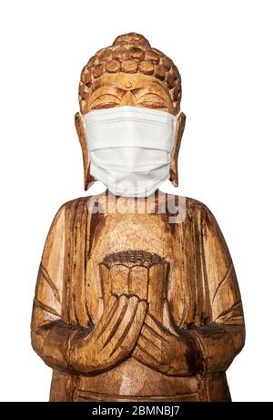 Buddha Holzstatue trägt Gesichtsmaske. Isoliert über Weiß. Covid-19-Konzept Stockfoto