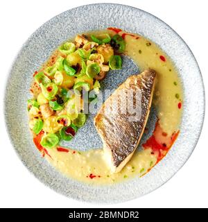 Schmackhaftes gegrilltes Seebarsch-Filet mit gedünsteten rosenkohl, gerösteten Pilzen, Kartoffeln, karamellisierten Zwiebeln und cremiger Sauce, gesundes Abendessen. Isol Stockfoto