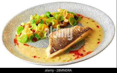Schmackhaftes gegrilltes Seebarschfilet mit gedünsteten rosenkohl, gebratenen Pilzen, Kartoffeln, karamellisierten Zwiebeln und cremiger Sauce. Isoliert über Weiß Stockfoto