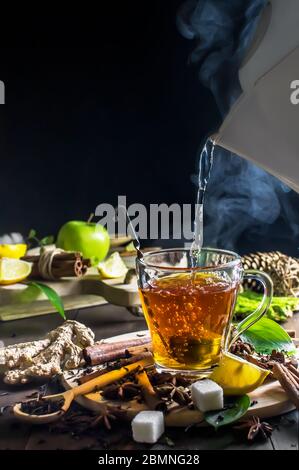 Heißes Wasser wird aus dem Wasserkocher in eine Tasse Tee gegossen Stockfoto