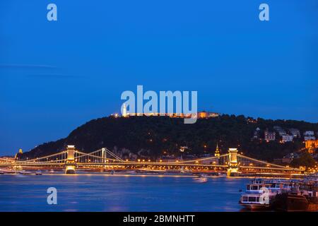 Gellert-Hügel mit Zitadelle in Budapest bei Nacht, beleuchtete Brücken auf Donau, Hauptstadt von Ungarn Stockfoto