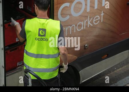 Ein Ocado-Mitarbeiter packt den Supermarkt aus, um eine Lieferung nach Hause zu erhalten Stockfoto