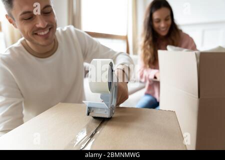 Nahaufnahme lächelnden Mann Versiegelung Box mit Klebeband Stockfoto