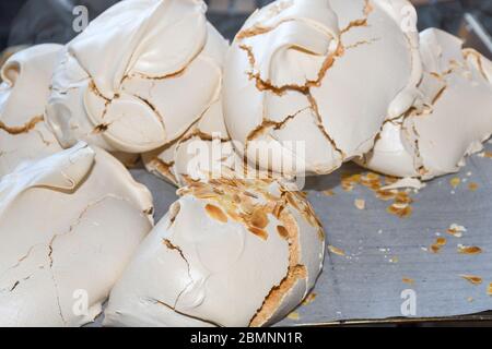 Baiser. Süßer Baiser. Tablett mit Baiser. Nahaufnahme des Meringue-Fotos. Hintergrund des Nachtischs. Hausgemachte Baiser-Kuchen mit Schlagsahne. Draufsicht. Stockfoto