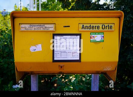 Gelbe Briefkasten aus Stahlblech. Dieses ist für die Region Düsseldorf. 'Andere Orte' bedeutet 'andere Ziele'. Stockfoto