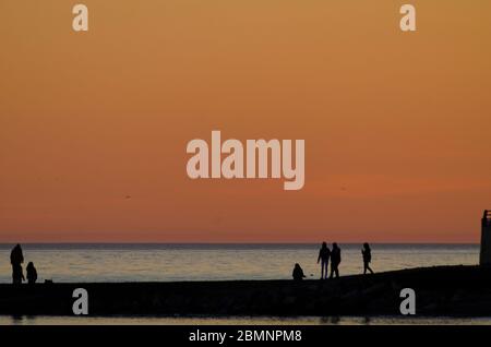 Menschen am Strand in der Abenddämmerung in Alexandroupoli Griechenland Stockfoto