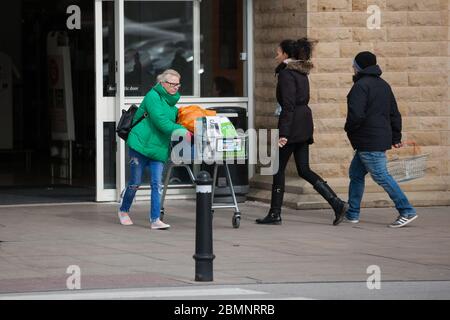HUDDERSFIERLD, WEST YORKSHIRE, UK - MÄRZ 21: Ein Käufer verlässt einen Supermarkt mit einer Kiste Bier am Morgen nach dem Auftrag von Premierminister Boris Johnson Stockfoto