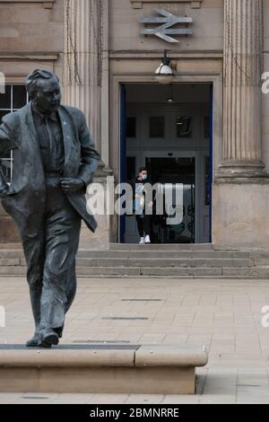 HUDDERSFIERLD, WEST YORKSHIRE, UK - MÄRZ 21: Ein Mann in einer Gesichtsmaske verlässt den Bahnhof Huddersfield. Stockfoto