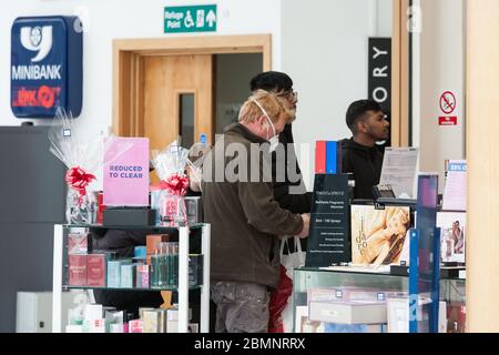 HUDDERSFIERLD, WEST YORKSHIRE, Großbritannien - MÄRZ 21: Ein Mann, der eine Gesichtsmaske trägt, kauft am Vortag des Muttertags im Kingsgate Shopping Centre, Hudder, Parfüm Stockfoto