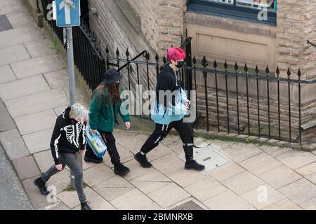 HUDDERSFIERLD, WEST YORKSHIRE, Großbritannien - MÄRZ 21: Menschen mit Gesichtsmasken gehen durch das Stadtzentrum von Huddersfield. Stockfoto