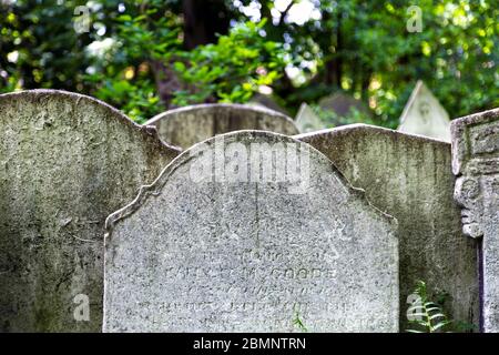 Nahaufnahme von alten Grabsteinen im Tower Hamlets Cemetery Park, London, Großbritannien Stockfoto