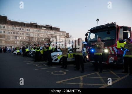 Polizeibeamte und Feuerwehrleute aus West Yorkshire stellen sich vor dem Huddersfield Royal Infirmary zusammen, um während des C Anerkennung für die Gesundheitsarbeiter zu zeigen Stockfoto