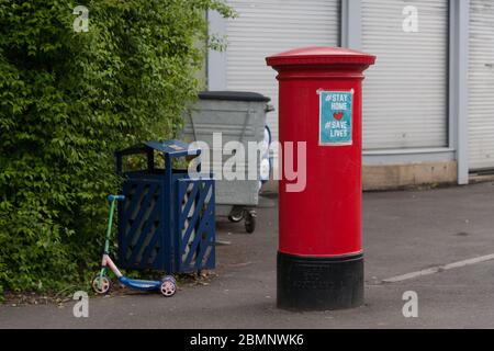 Meltham, UK - 5. Mai 2020: Ein verlassene Roller sitzt während des Lockdown neben einem Briefkasten. Stockfoto