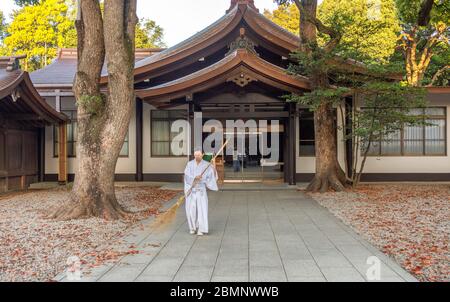 Tokio / Japan - 21. April 2018: Mönch fegen Blätter am Meiji-Schrein (Meiji Jingu), Shinto-Schrein, der den deifizierten Geistern von Kaiser Meij gewidmet ist Stockfoto