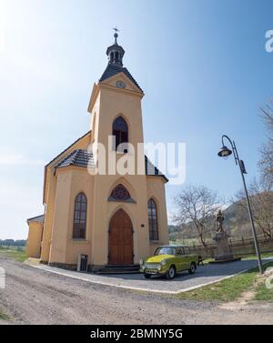 Grüner Trabant Limousine Parkplatz vor dem Eingang der Kirche von St. Anthony. 17. April 2020, Hermanice / Podjestedi, Tschechische Republik Stockfoto