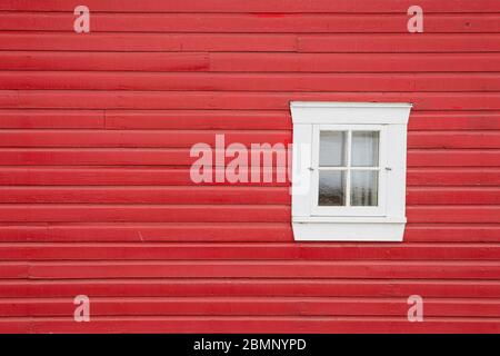 Die klassische rote Holzscheune mit einem einzigen weißen Fenster Stockfoto