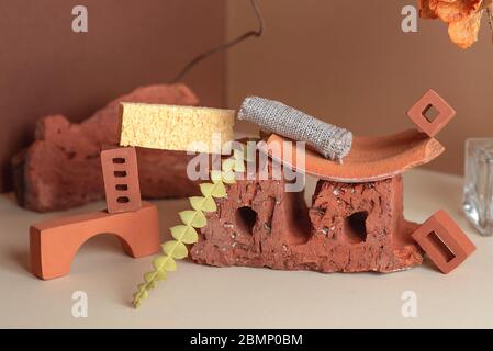 Geometrische Zusammensetzung aus Ziegeln, Glasflasche und Pflanzen. In einem Eckraum von zwei Farben. Stockfoto