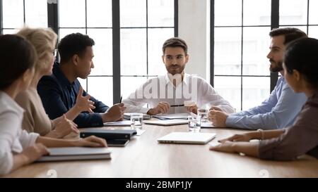 Serious Geschäftsmann zuhören reifen Mitarbeiter über Projekt sitzen am Tisch. Stockfoto