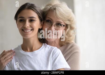 Glücklich reif Mutter Umarmungen von hinter erwachsenen Tochter. Stockfoto