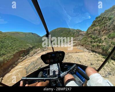 Der Helikopterpilot ist auf der letzten Annäherung an eine kleine Landezone neben dem Wasserfall. Hier ist Präzisionsfliegen gefragt, um sicher zu landen. Stockfoto