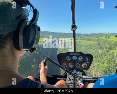 Dieser Pilot steuert seinen Hubschrauber direkt auf einen Abgrund zu. In einem Moment muss er sich entscheiden, sich umzudrehen oder eine scharfe Kurve zu fliegen. Stockfoto