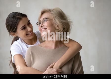 Erwachsene Tochter Umarmungen von hinten glücklich reif Mutter. Stockfoto