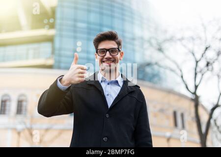 Junge erfolgreiche Geschäftsmann der Stadt Straße. Daumen nach oben angehoben. Stockfoto