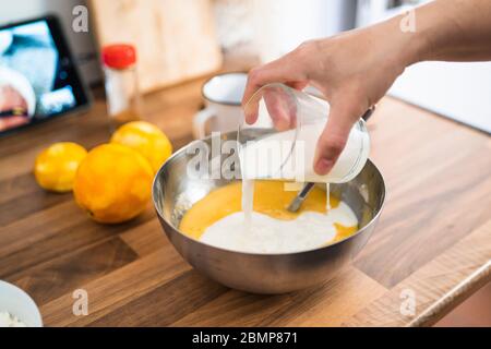 Frau macht ein Kuchen Rezept via online in ihrer Küche Stockfoto