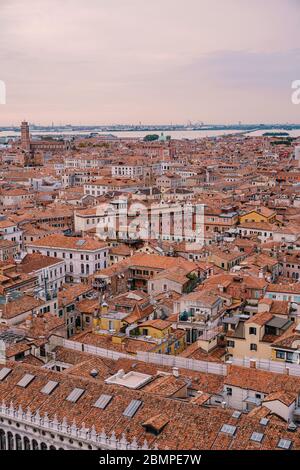Luftpanorama vom Glockenturm der Kathedrale San Marco Campanile des alten historischen Stadtzentrums, des Meeres, der roten Ziegeldächer und der Paläste. Venice, Italien - Stockfoto
