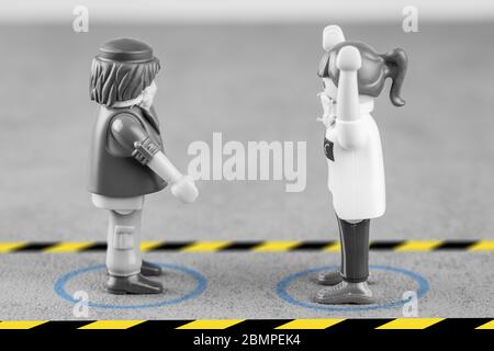 Playmobil Charakter illustriert die Markierung auf dem Boden und Beschilderung, für physische Entfernung auf der Straße oder im Rahmen der Arbeit zu vermeiden transmi Stockfoto