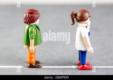 Playmobil Charakter illustriert die Markierung auf dem Boden und Beschilderung, für physische Entfernung auf der Straße oder im Rahmen der Arbeit zu vermeiden transmi Stockfoto