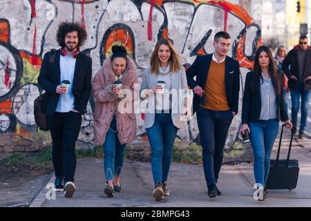 Eine Gruppe von Freunden (Kollegen), die in einem städtischen Gebiet aufhängen. Stockfoto