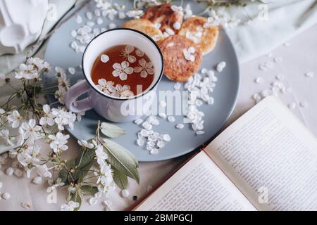 Frühstück am Morgen, getoastete schöne Käsekuchen auf einem Teller auf der Tischdecke neben einem Frühlingsstrauß aus weißen Blumen Stockfoto