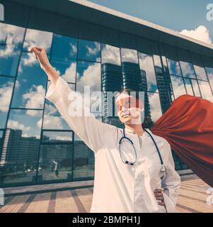 Ärztin in einem Superhelden Cape ist bereit zu helfen. Stockfoto