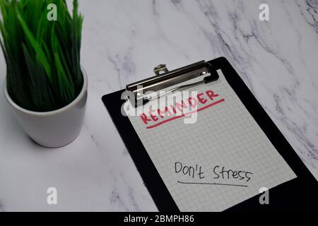 Erinnerung und nicht Stress Schreiben auf Zwischenablage isoliert auf Büroschreibtisch Stockfoto