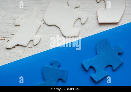 Fragmente des Puzzles auf einem zweifarbigen Hintergrund. Weiße und blaue unmontierte Rätsel über und unter der Diagonallinie. Psychologische Tests. Profes Stockfoto