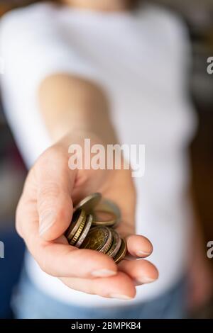 Kleiner Haufen Münzen in einer weiblichen Hand. Konzept der Krise und Geld sparen. Stockfoto