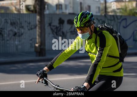 UKRAINE, KIEW - 25. April 2020: Professionelle Fahrradfahrer fährt mit einer medizinischen Maske, um eine bakterielle Infektion Corona Virus oder Covid 19 epi zu verhindern Stockfoto