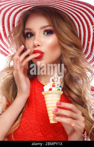 Helle fröhliche Mädchen im Sommer Hut, bunte Make-up, Locken, rosa Maniküre und Eis in den Händen. Beauty Face. Stockfoto