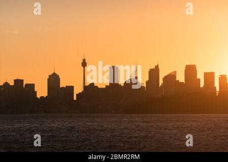 Sydney Stadtbild mit hellem orangefarbenen Himmel und dunklen Silhouetten von Sydney CBD Wolkenkratzern und Büro- und rezidenziellen Gebäuden. Skyline von Sydney Stockfoto