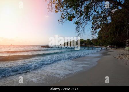 Fantastischer tropischer Strand mit einer Silhouetten-Holzbrücke aus dem Strand tropisch / Boardwalk oder Holzsteg zum Horizont auf dem Meer Ozeanparadies Stockfoto