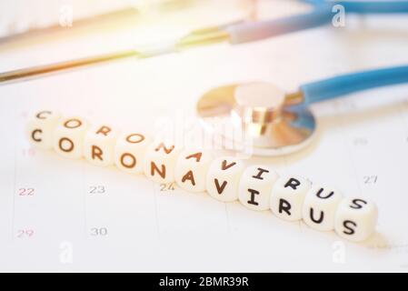 Coronavirus Wörter und Stethoskop auf Kalender / COVID-19 Coronavirus Ausbreitung Grippe medizinische Krise Pandemie öffentliche Gesundheit Risiko Prävention Stockfoto