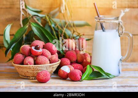 Frische Litschi trinken und schneiden mit grünen Blättern geschält Ernte im Korb von Baum tropische Frucht Sommer in Thailand / Lychee Saft auf Holztisch Stockfoto