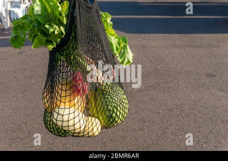 Frische Bauern produzieren in schwarzen Netzbeutel. Umweltfreundliches Mehrweg-Einkaufstasche-Alternativkonzept Stockfoto